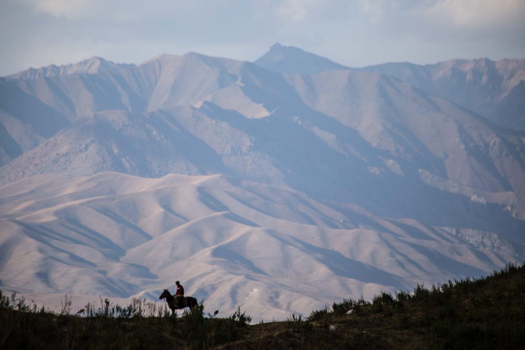 Horseman in silhouette on the descent from Ak Tash in Naryn