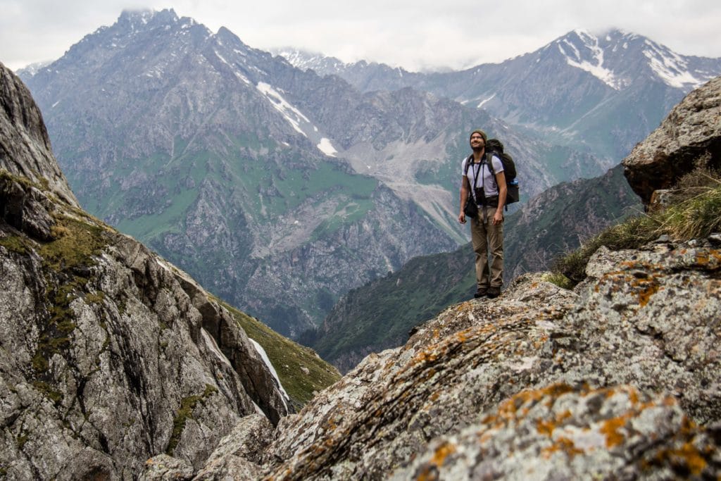 Hiker climbing from Karakol Valley to Alakol
